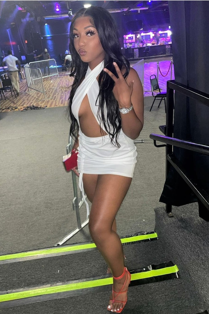 woman wearing white mini dress with adjustable side drawstring, backless, cross tie top